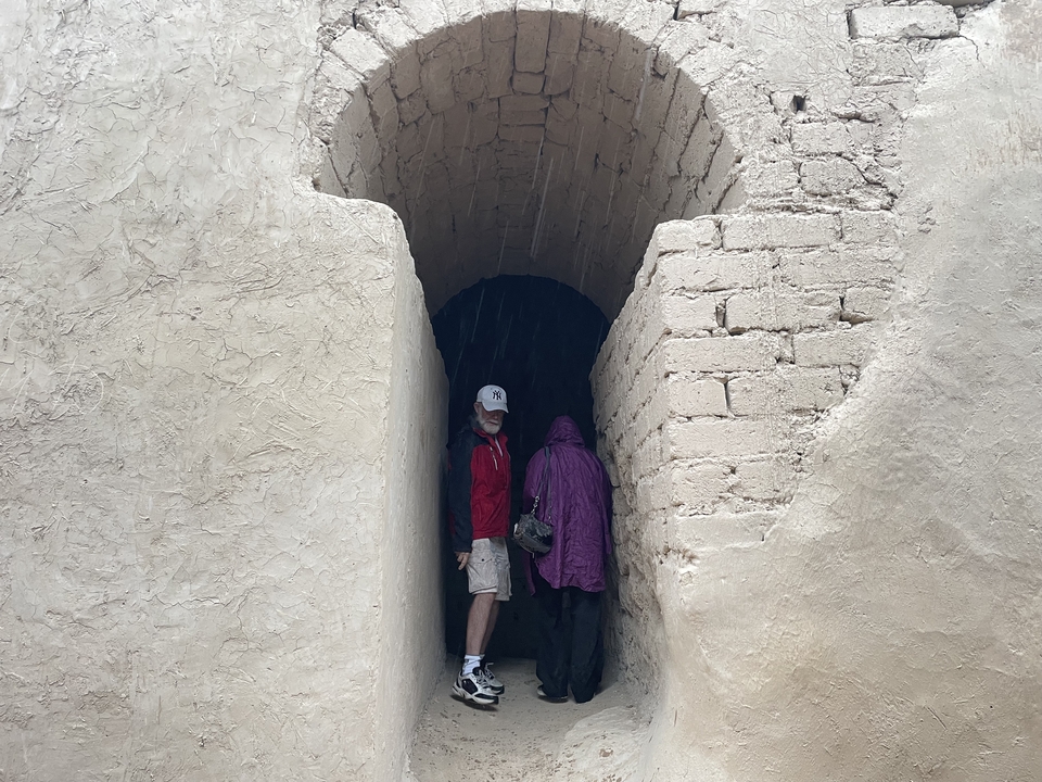 Personas entrando a una estructura con entrada arqueada.