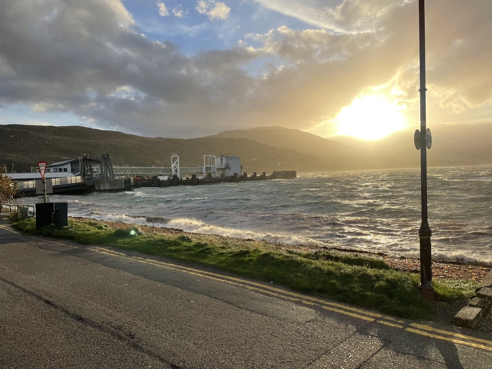 Terminal de ferry avec mer agitée et coucher de soleil.
