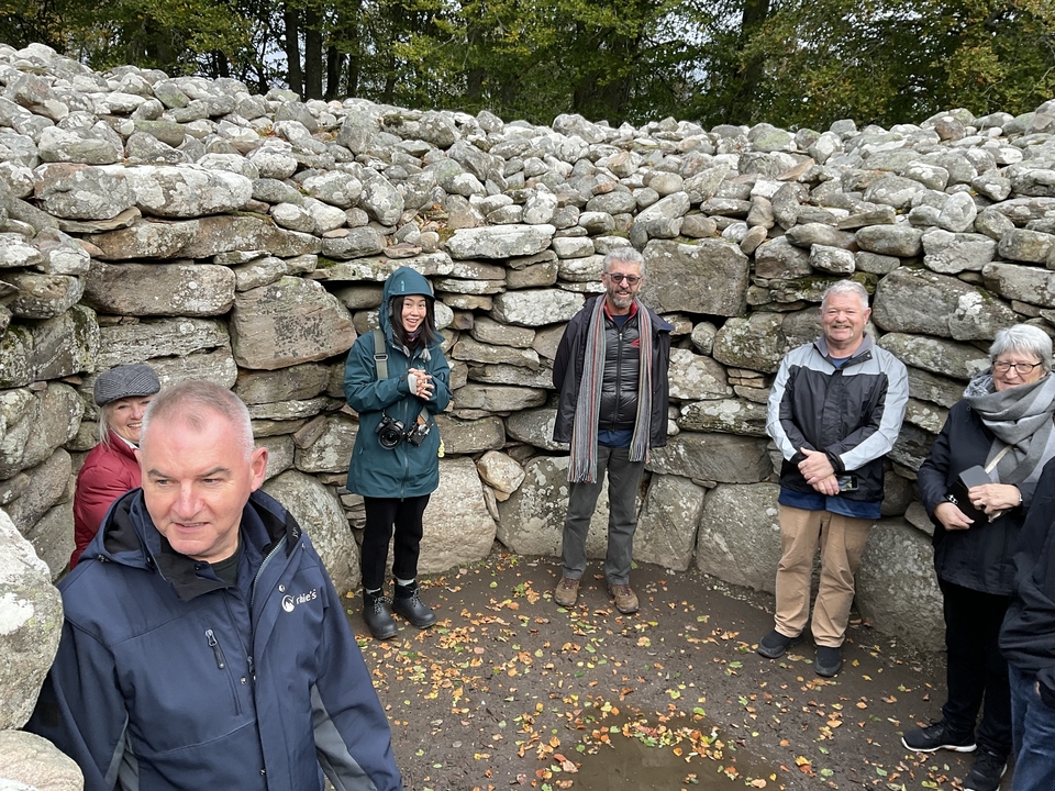 Groupe de personnes debout à l'intérieur d'un cercle de pierres.