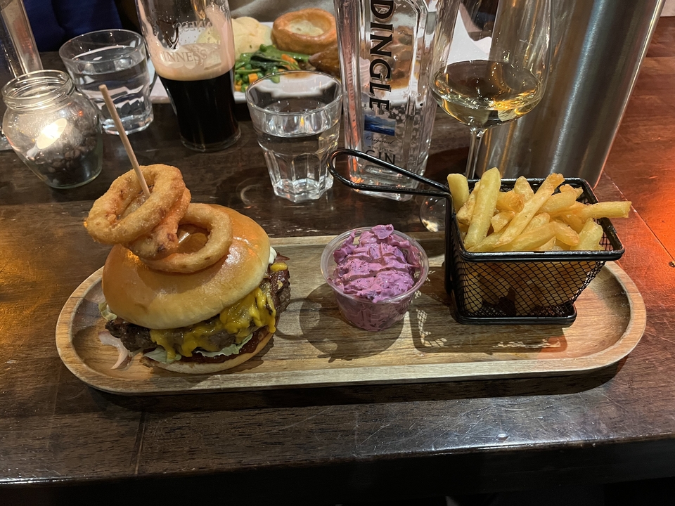Burger and fries served on a wooden tray.