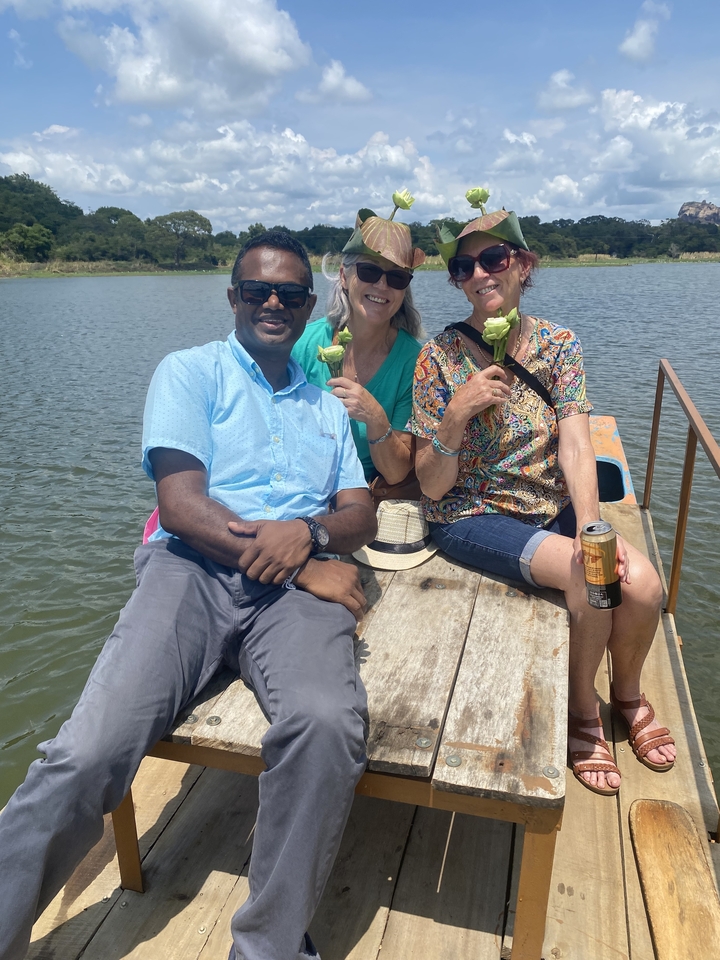 Trois personnes assises sur un bateau, tenant des fleurs.