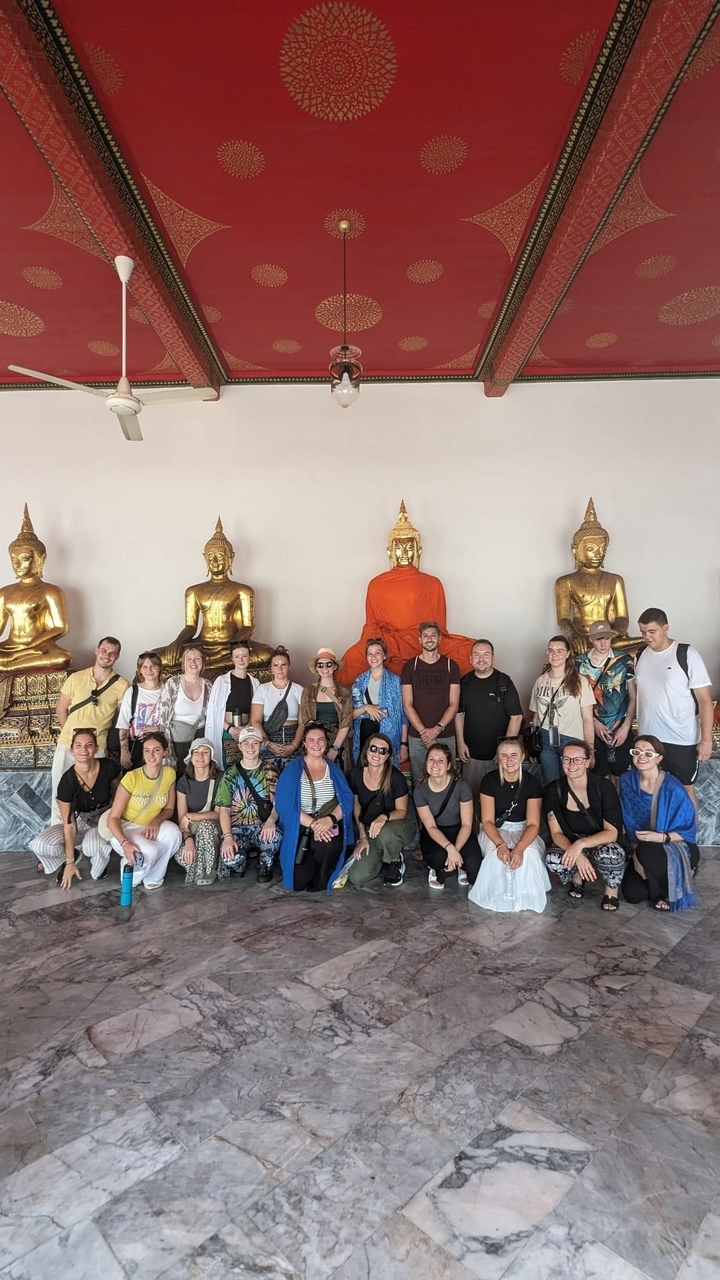 Grupo de personas posando con estatuas de Buda.