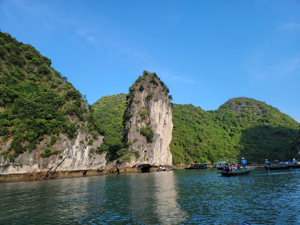 Falaises calcaires et bateaux sur une baie sereine.