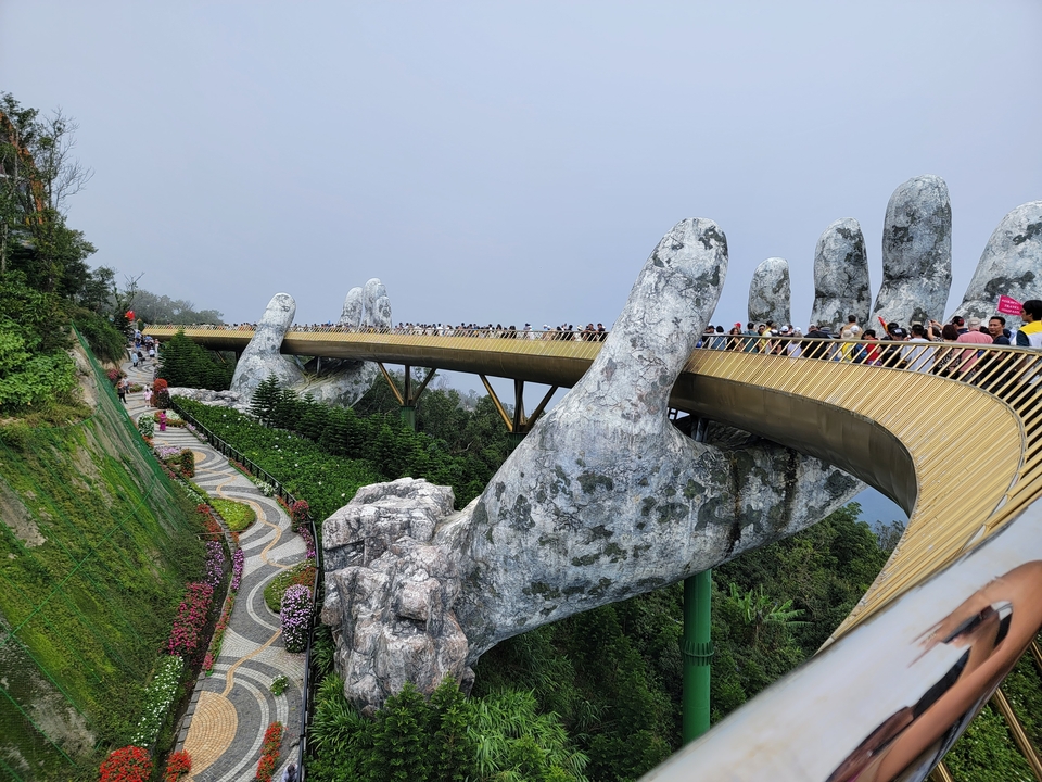 Pont Doré tenu par des mains géantes dans le brouillard.