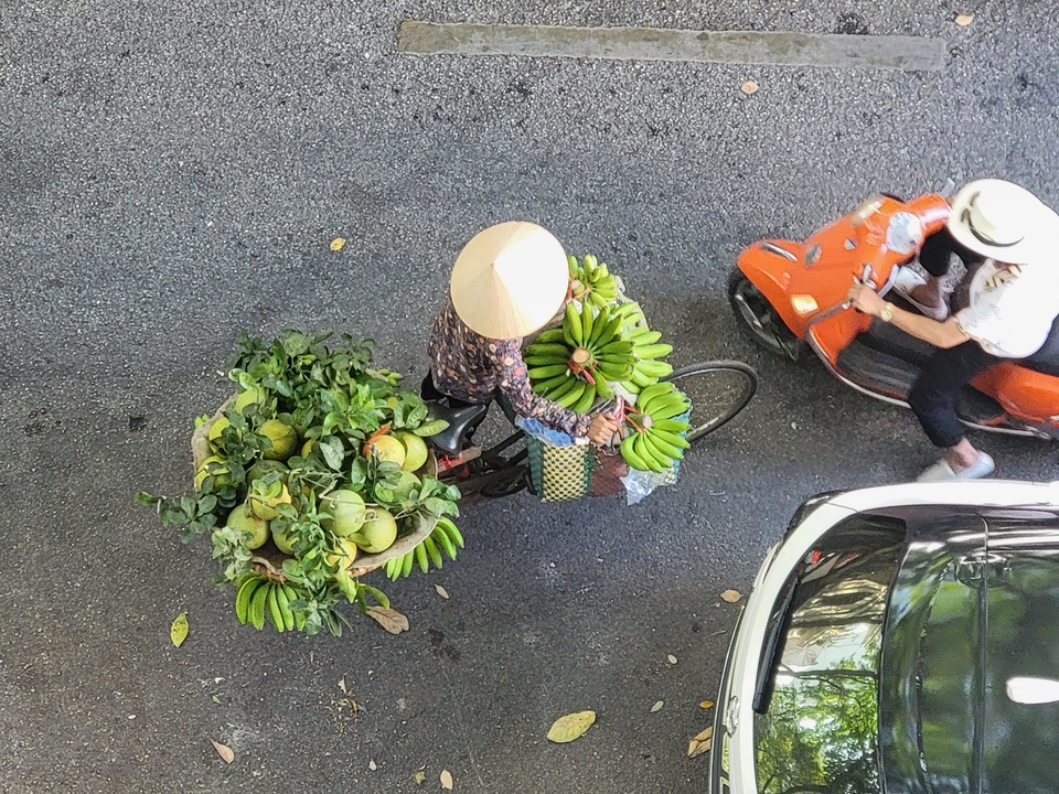 Vendeur avec bicyclette chargée de produits.