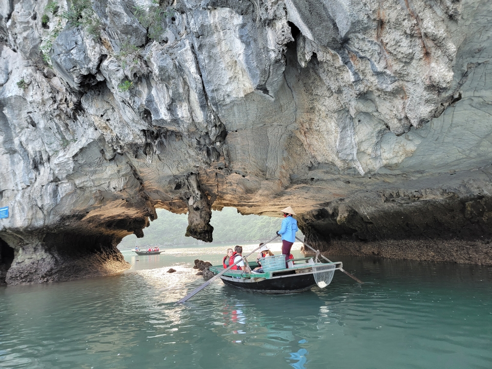 Bateau sous une formation rocheuse dans la baie d'Halong.