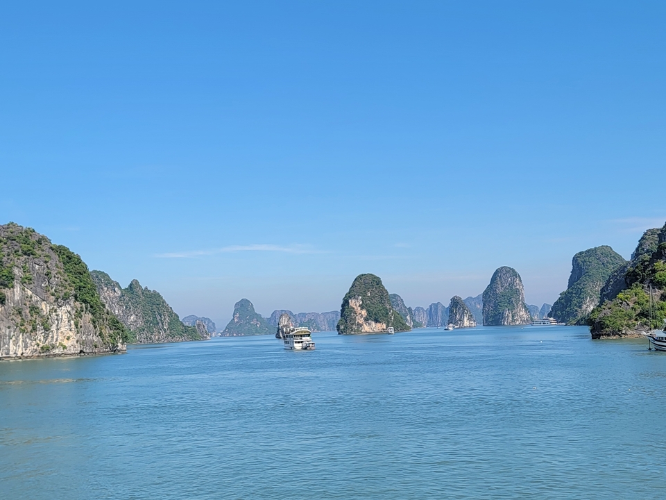 Bateaux naviguant à travers les karsts calcaires de la baie d'Halong.