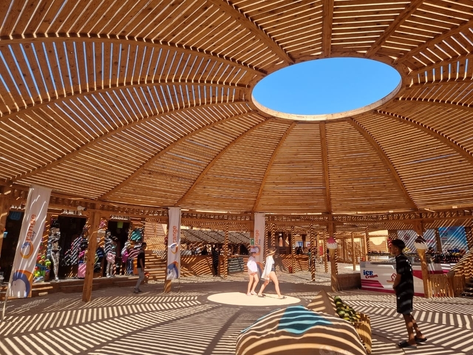 Structure circulaire en bois avec des personnes à l'intérieur.