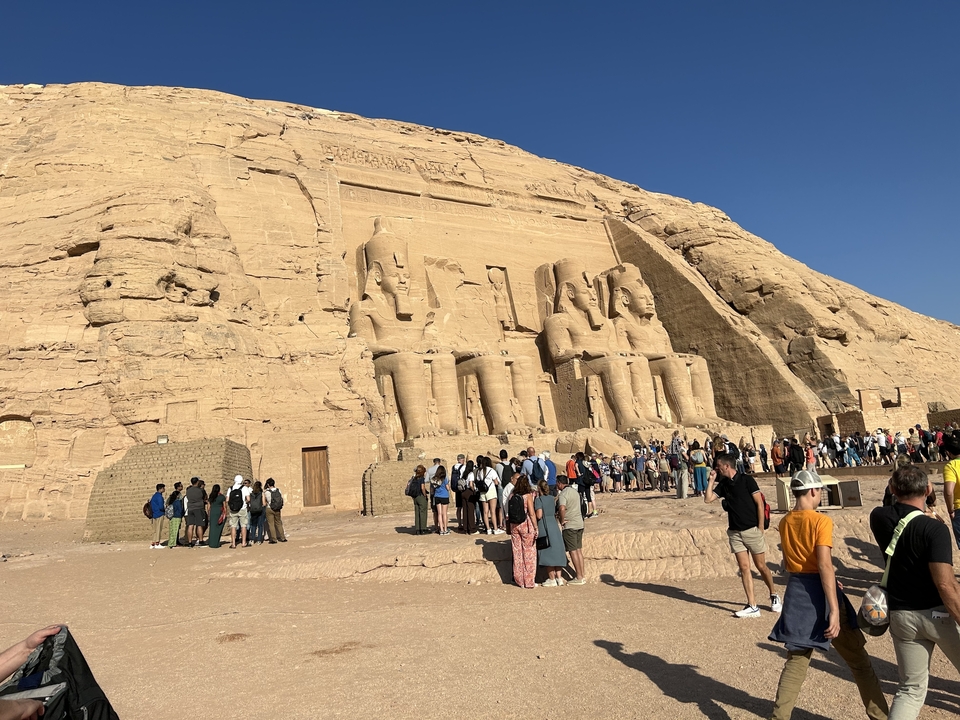 Une grande groupe de personnes visitant les temples d'Abou Simbel.