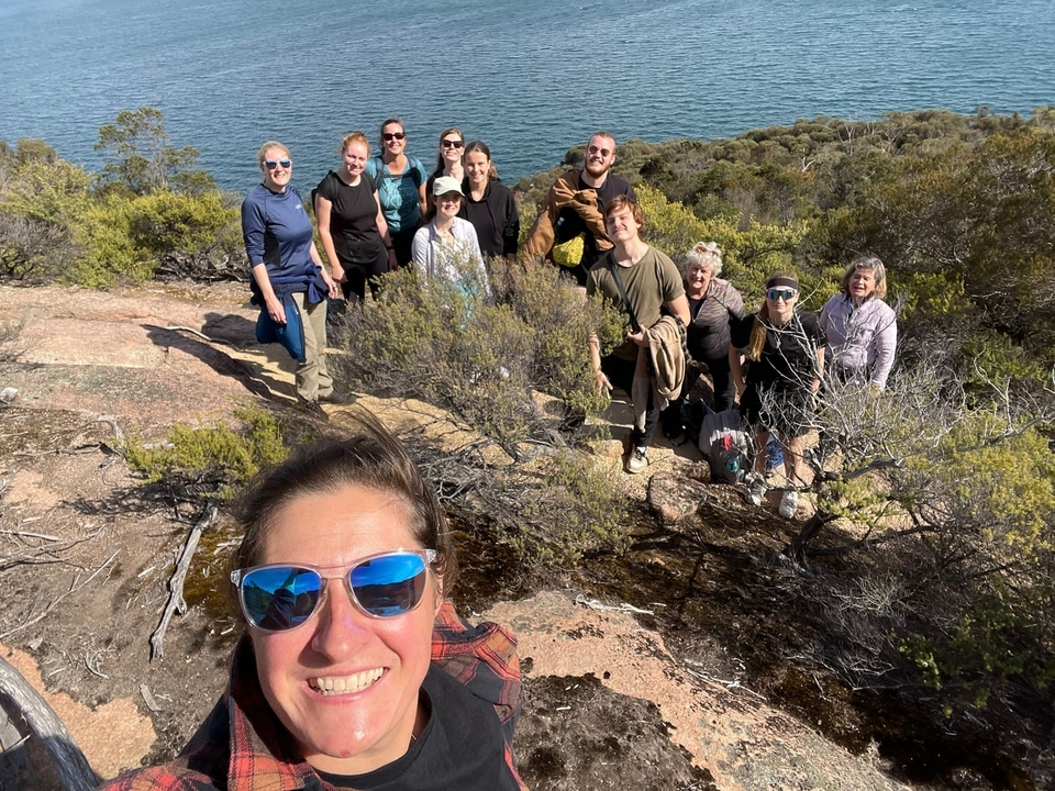 Groupe de personnes sur un terrain rocheux avec vue sur l'océan.