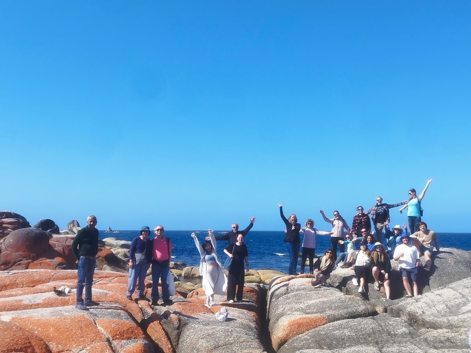 Groupe de personnes posant sur un littoral rocheux.