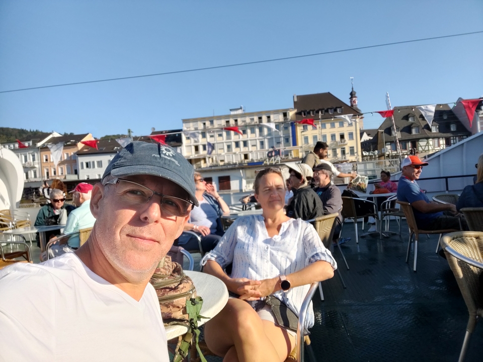 Un groupe de personnes se détendant sur un bateau avec des bâtiments de la ville visibles.