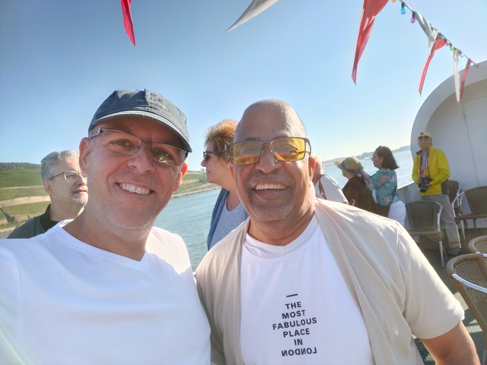 Deux amis qui posent sur un bateau avec une rivière en arrière-plan.