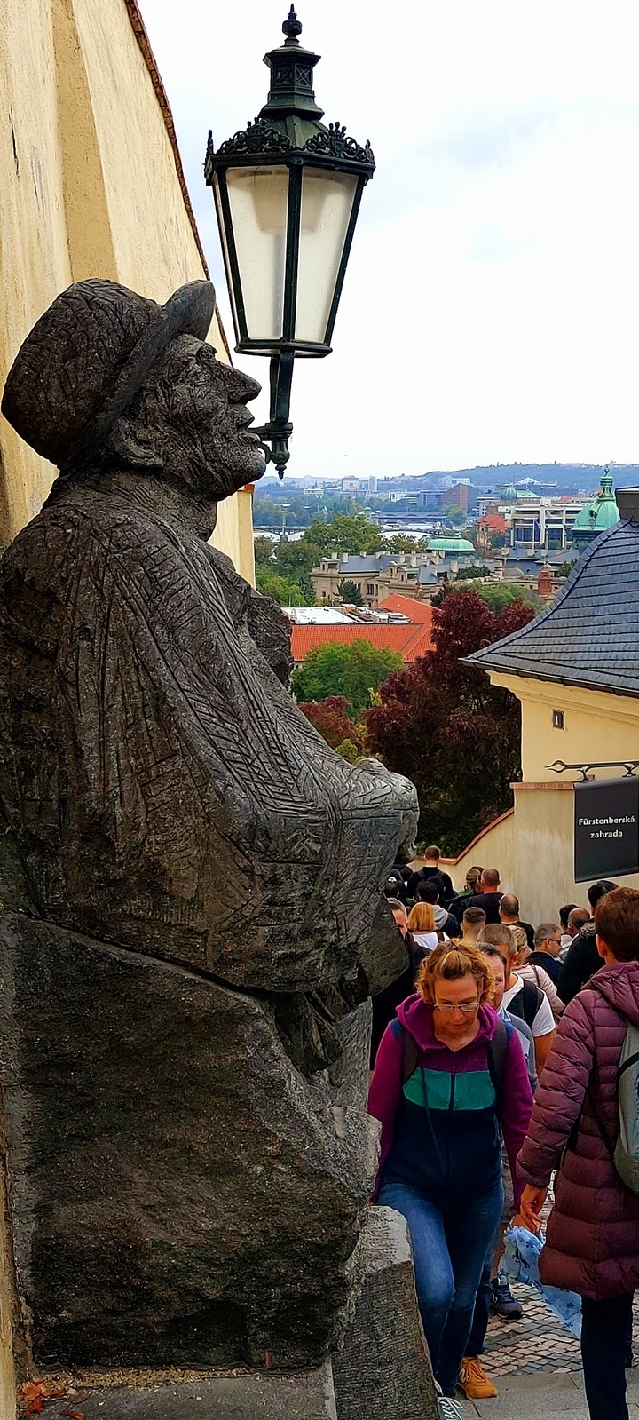 Grande statue de pierre avec vue sur la ville en arrière-plan.