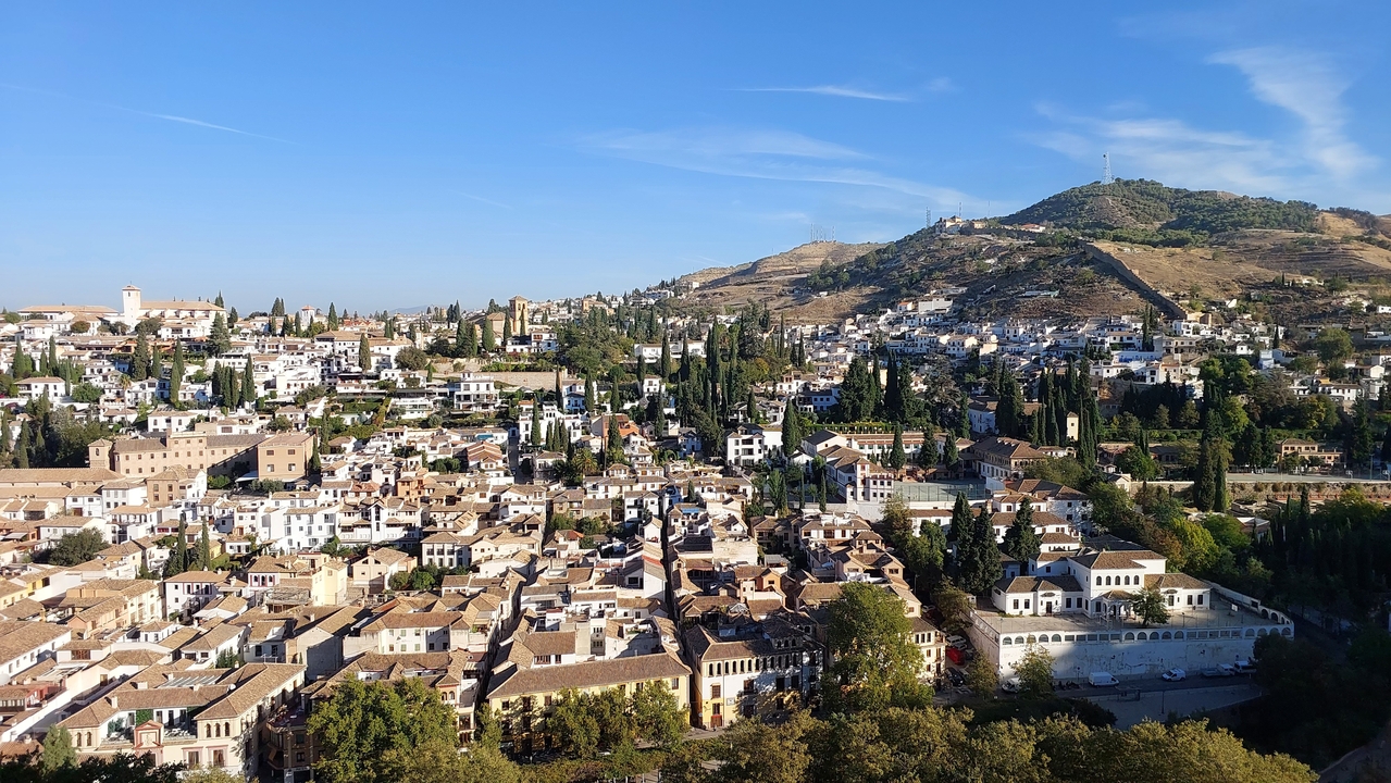 Vue panoramique d'une ville avec des collines en arrière-plan.