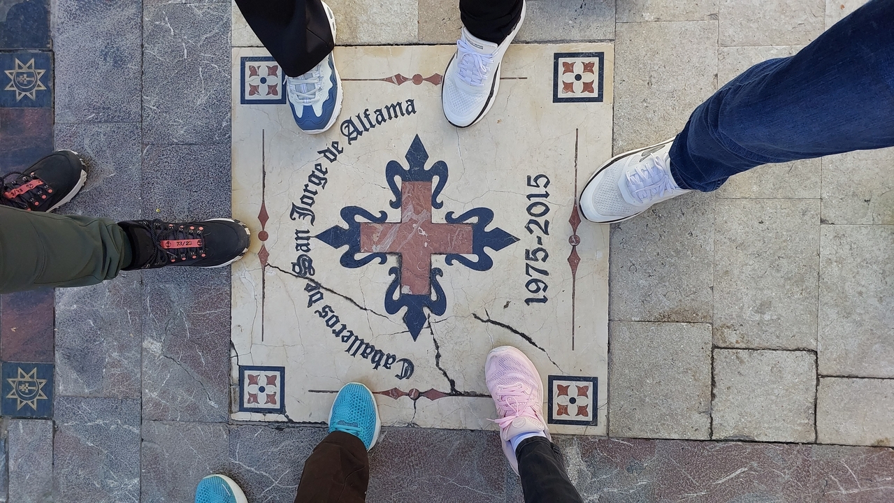 Carreau décoratif au sol entouré de chaussures.