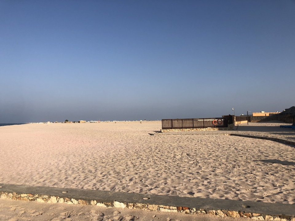 Beach area with a sandy shore and structures.