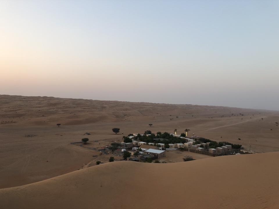 Aerial view of a desert settlement surrounded by dunes.