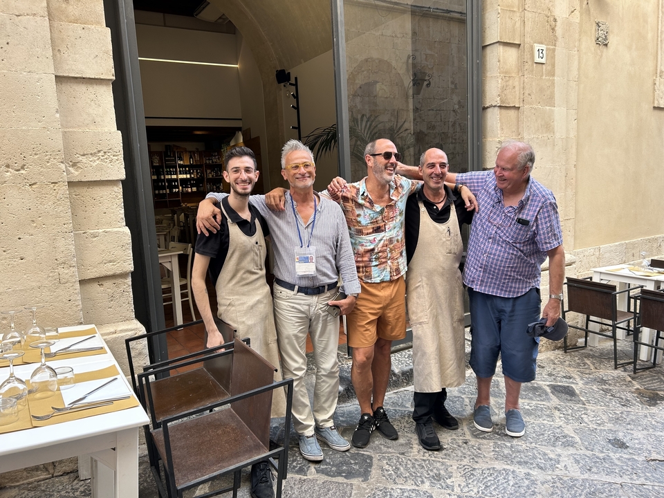 Groupe de cinq personnes posant devant un restaurant.