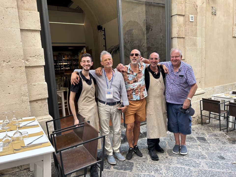 Groupe de cinq personnes posant devant un restaurant.
