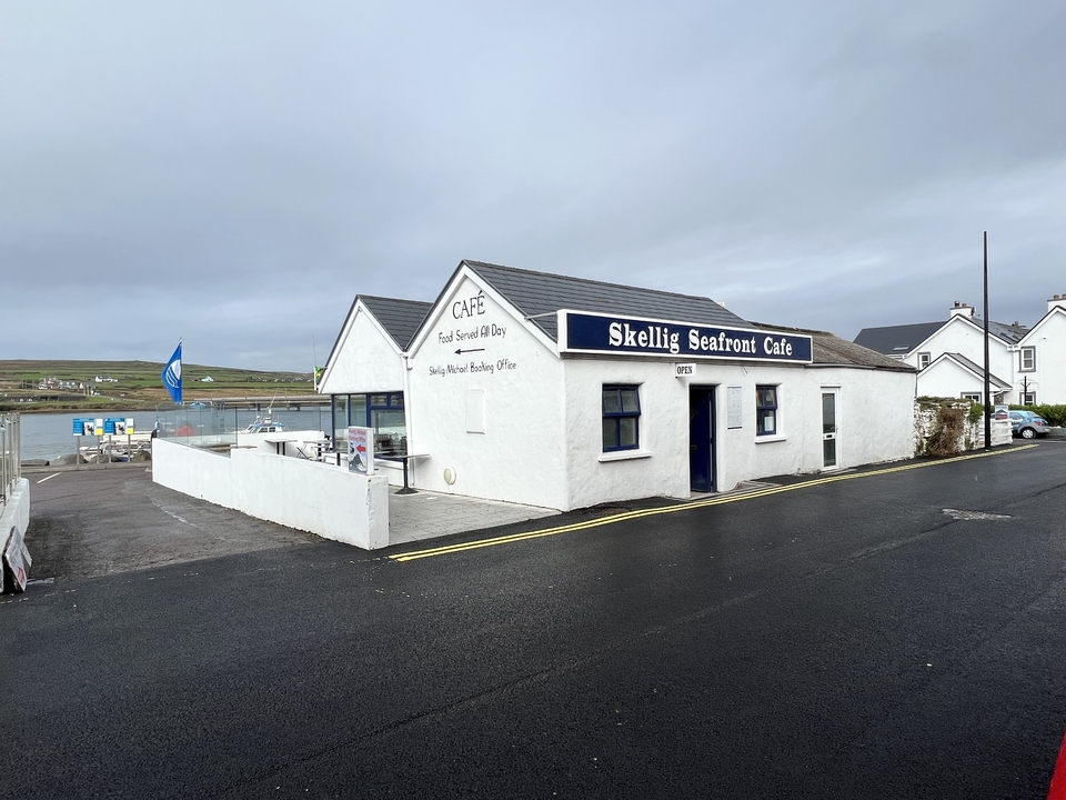 Café en bord de mer près de l'eau avec un ciel dégagé.