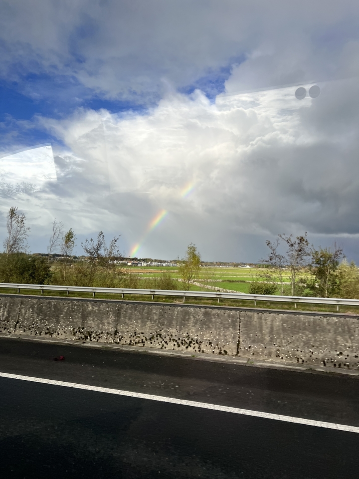 Champ avec un arc-en-ciel visible dans le ciel.
