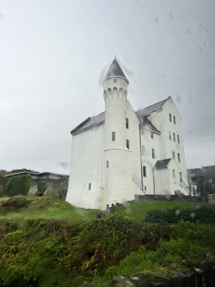 Un bâtiment blanc semblable à un château avec des tours rondes.