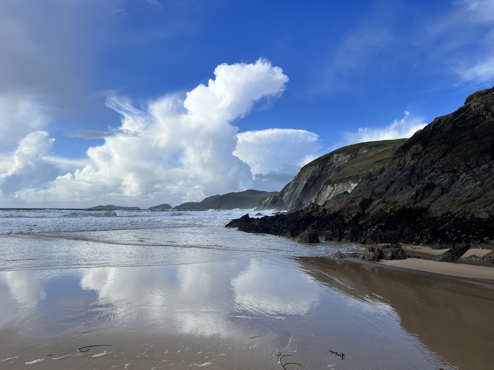 Une plage pittoresque avec de l'eau réfléchissante et des falaises.