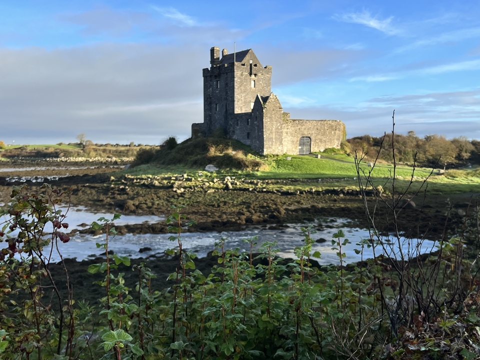 Paysage avec un château sur une colline au bord de l'eau.
