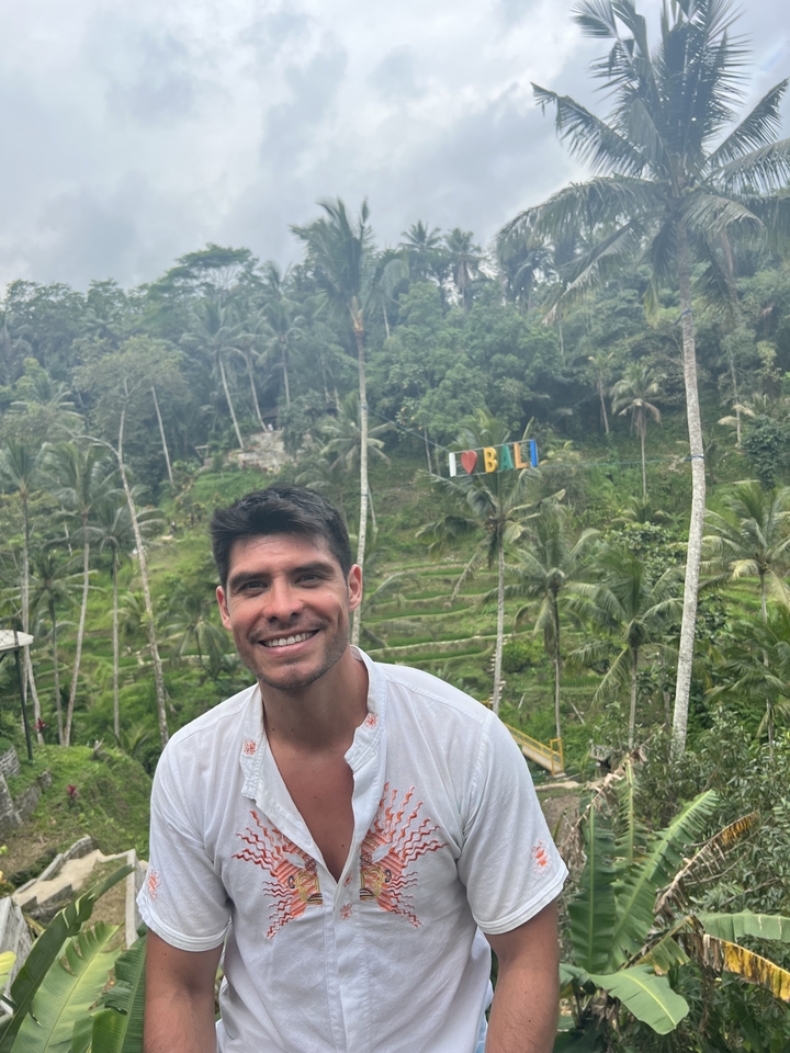 Personne posant avec un arrière-plan tropical luxuriant.