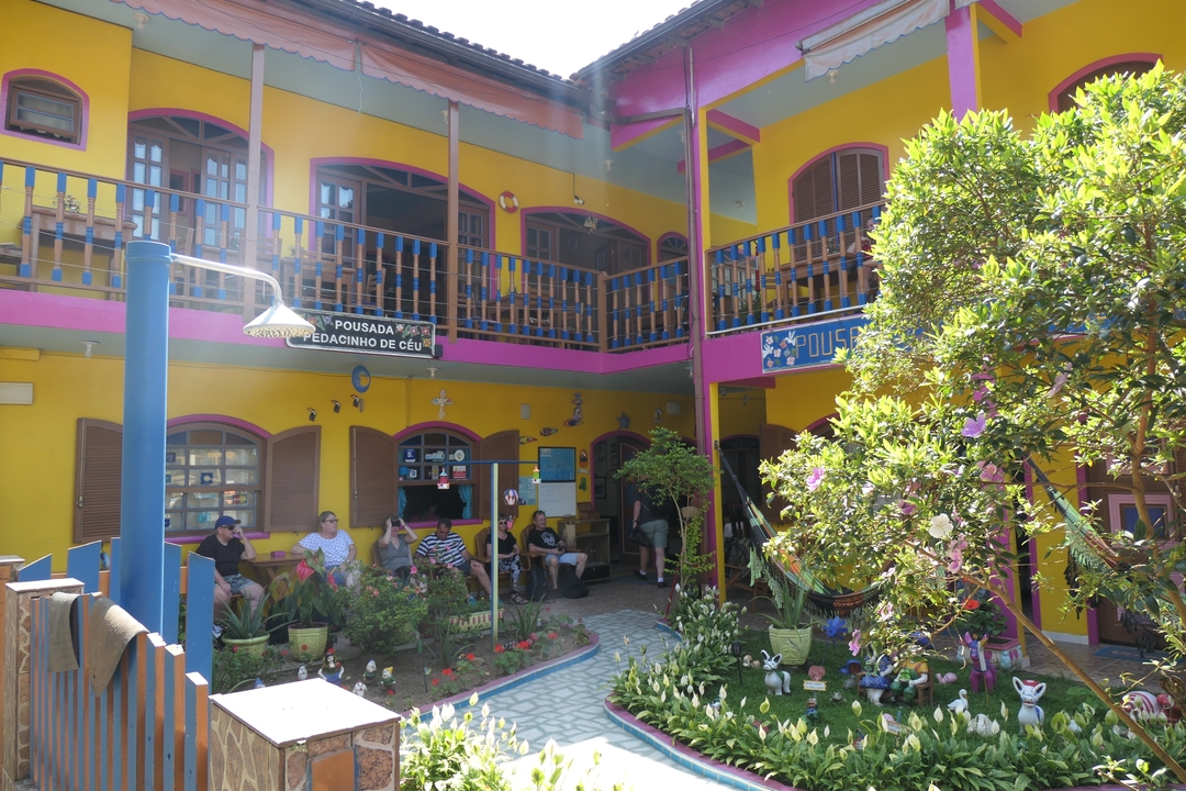 Cour d'auberge de jeunesse colorée avec des gens qui se détendent.