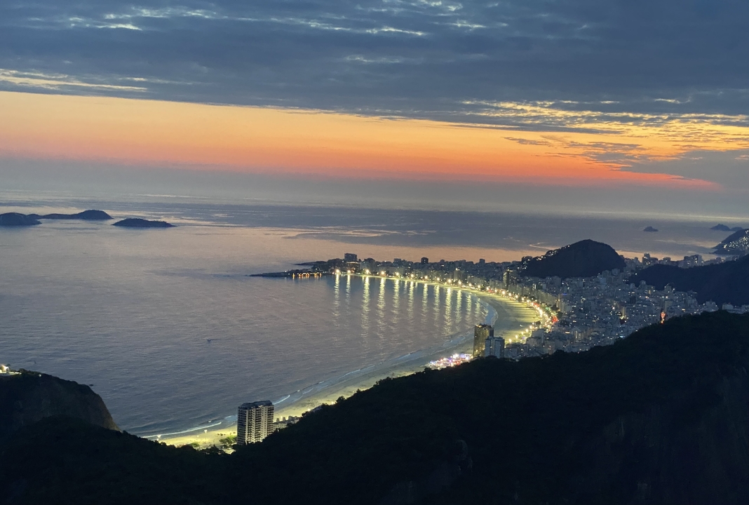Paysage urbain côtier au crépuscule avec des lumières le long du rivage.