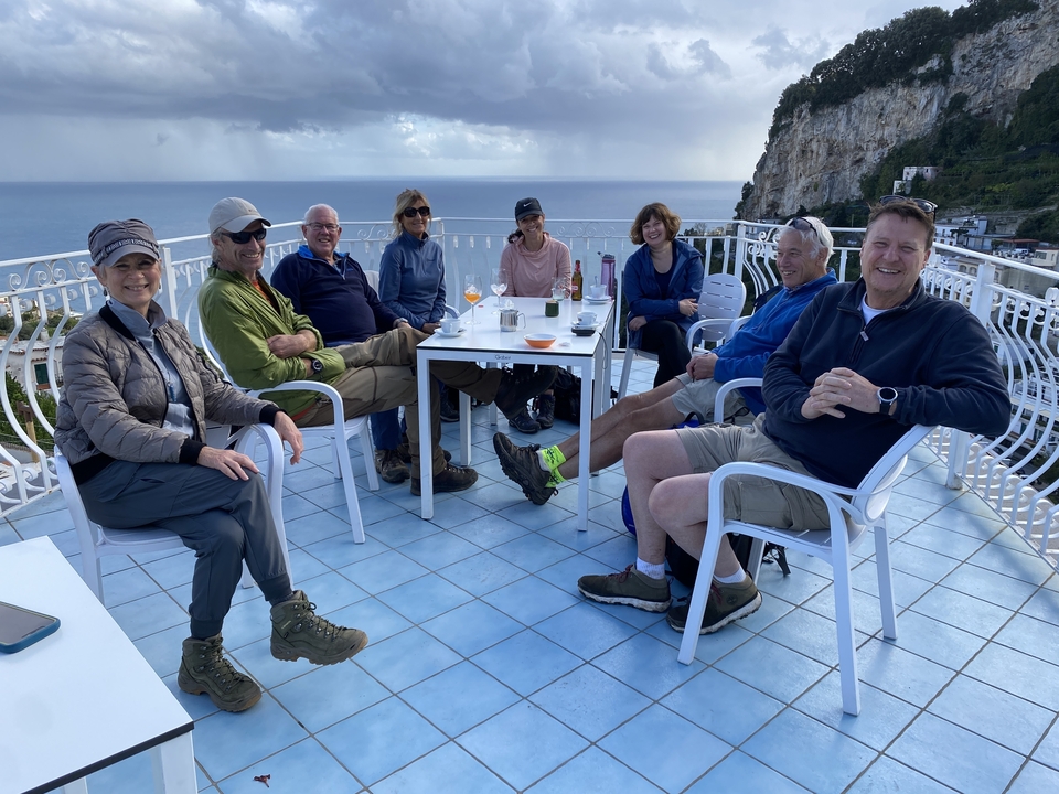 Groupe de personnes sur une terrasse avec vue sur la mer.
