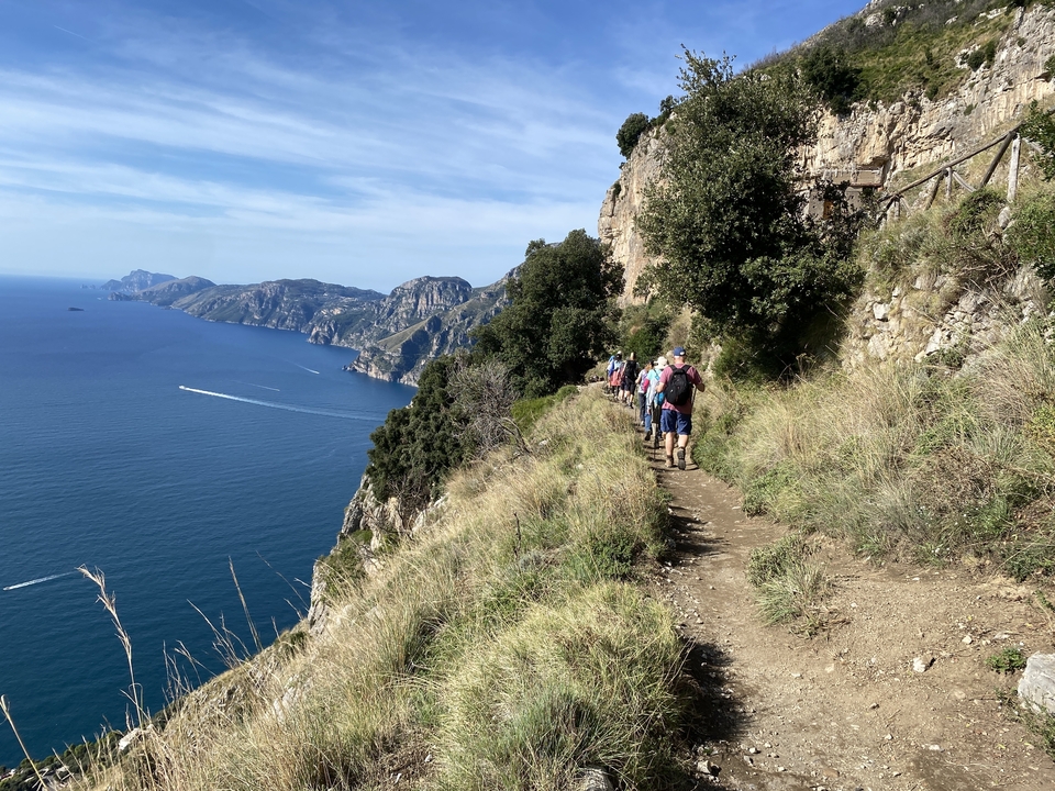 Des randonneurs marchant le long d'un sentier côtier.
