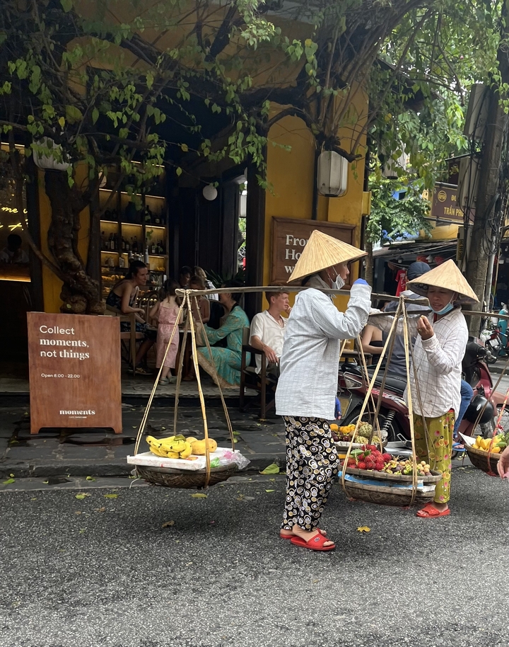 Vendeurs ambulants vendant des fruits tropicaux avec des habitants et des touristes.