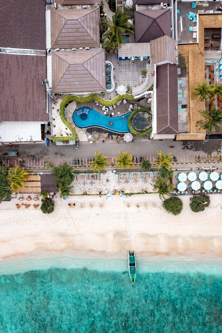 Vue aérienne d'une plage avec des chaises longues and une piscine.