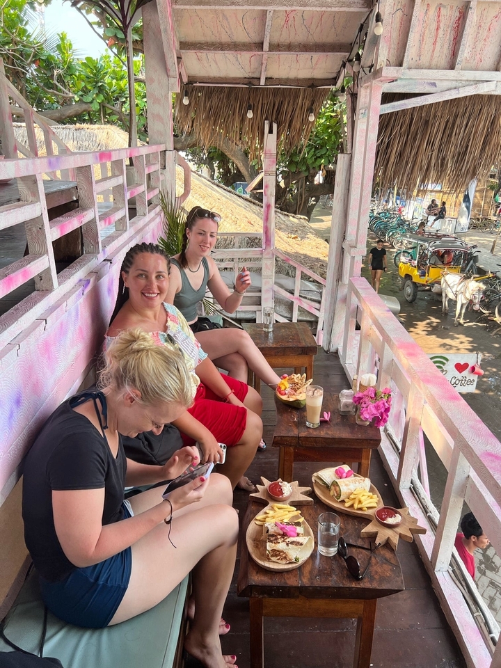 Des gens assis et se détendant dans un café avec vue sur la rue.
