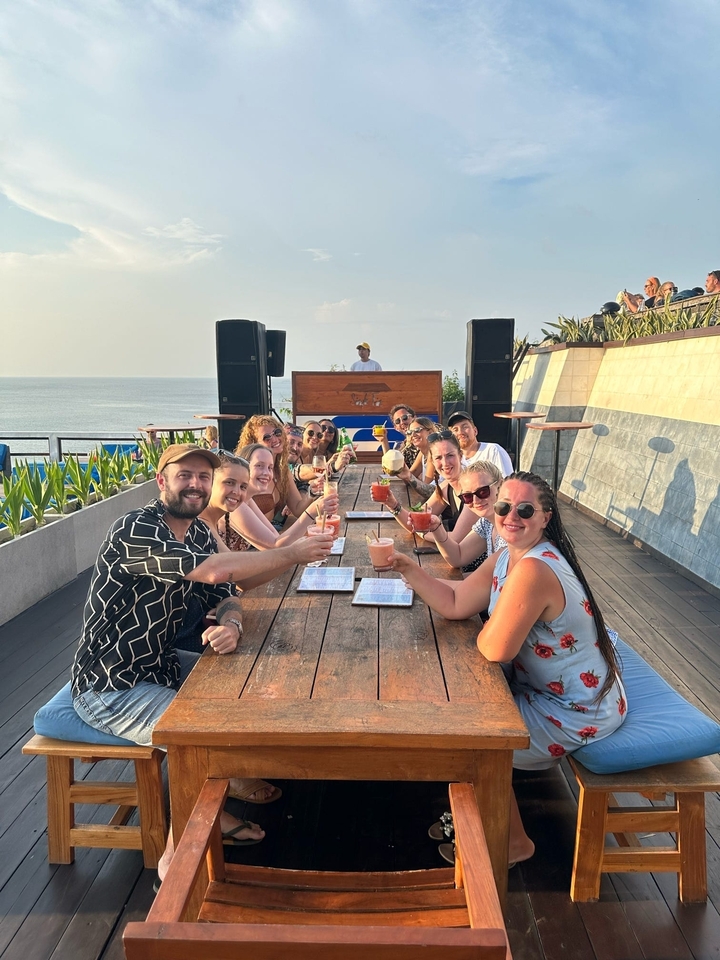 Groupe profitant de boissons sur un toit-terrasse avec vue sur l'océan.