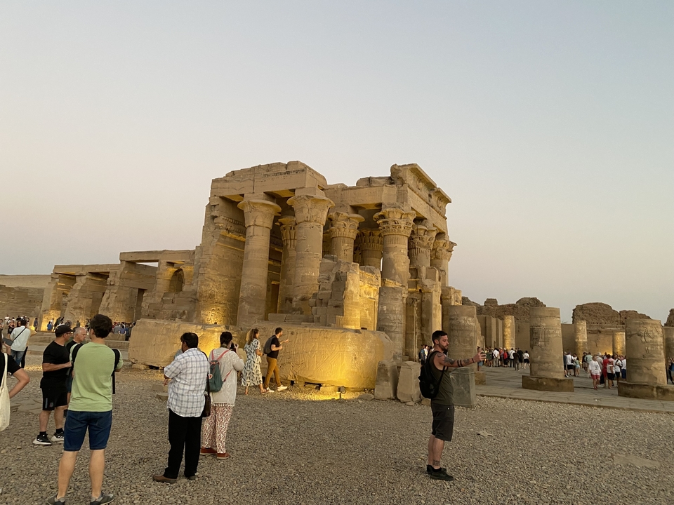 Touristes dans un temple antique au coucher du soleil.