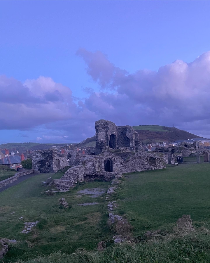 Ruines d'une structure en pierre avec des collines en arrière-plan.