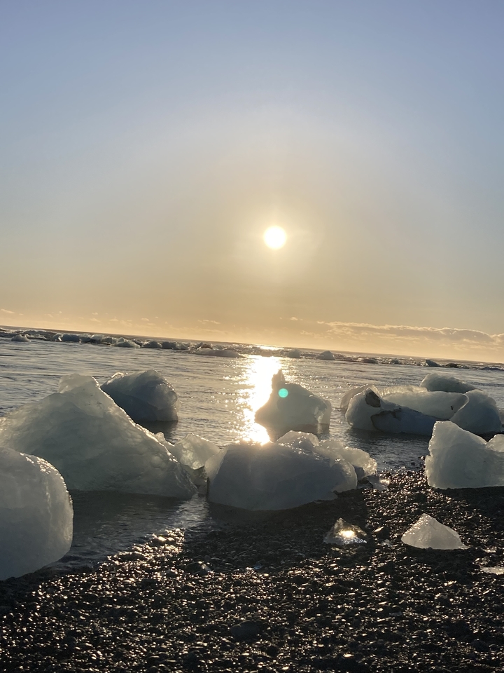 Vue du coucher de soleil sur des icebergs dans un océan calme.