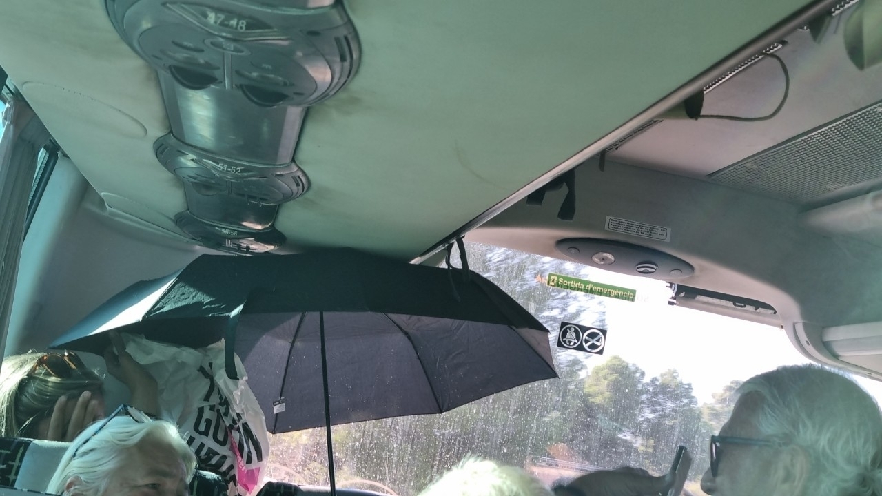 Des gens avec des parapluies dans un bus.