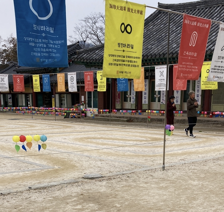 Banderoles et lanternes colorées avec deux personnes marchant dans un quartier traditionnel.