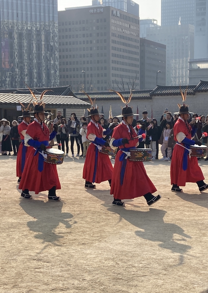 Groupe de marche traditionnel coréen en costumes colorés en représentation.