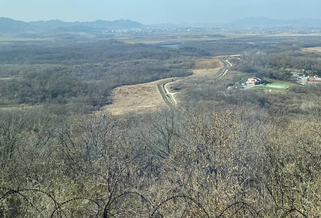 Vue large d'un terrain accidenté avec une végétation clairsemée.