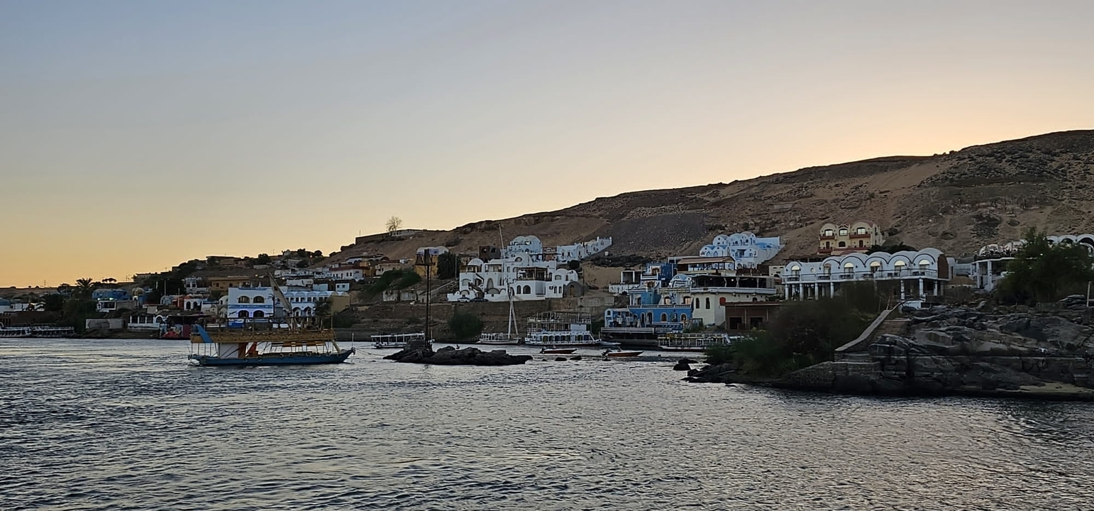 Petit village côtier avec des bâtiments blancs et bleus au bord de l'eau.