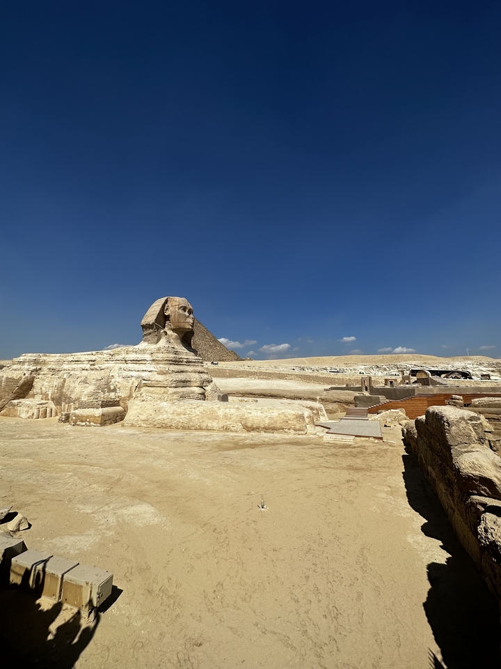 Sphinx avec une pyramide en arrière-plan sous un ciel bleu dégagé.