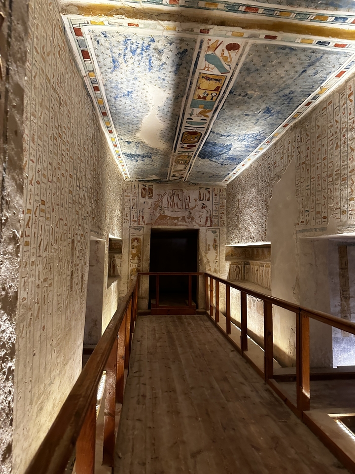 Intérieur d'un tombeau avec des peintures murales détaillées sur les murs.