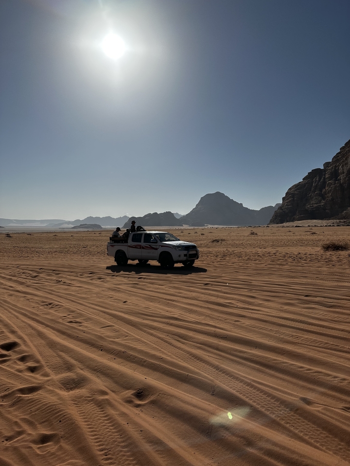 Véhicule tout-terrain sur le désert avec des montagnes en arrière-plan.