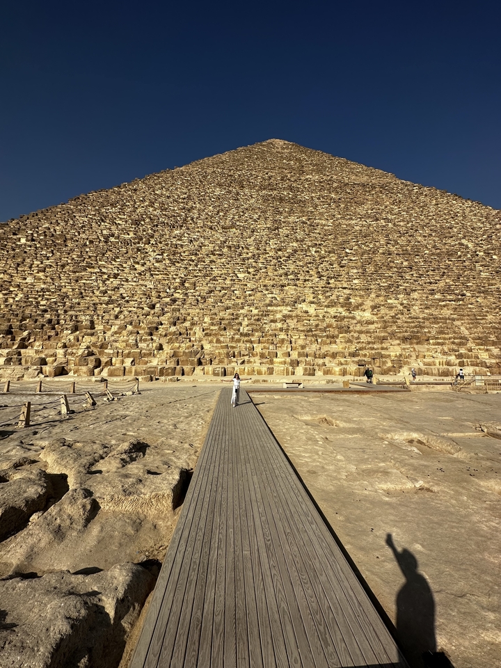 Personne debout devant la Grande Pyramide en Égypte.